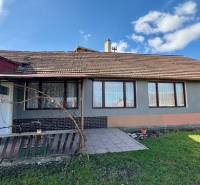 Rodinný dům v Mýtnych Ludanoch s dvorem, terasou a šedou fasádou.