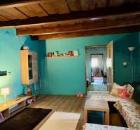 Pokoj v rodinném domě s podlahou s dřevěným dekorem a pohodlnými pohovkami.