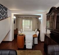 Jídelna s dřevěným nábytkem a podlahou s dřevěným dekorem v rodinném domě.