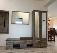 Chodba v 3-pokojovém bytě s věšákem a skříní, podlaha s dřevěným dekorem.