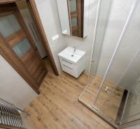 Koupelna s vanou, umyvadlem a podlahou s dřevěným dekorem ve 3pokojovém bytě.