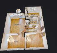 3pokojový byt s podlahou s dřevěným dekorem, kuchyní a lodžií.