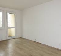 Pokoj s podlahou s dřevěným dekorem v 3-pokojovém bytě, stůl a židle.