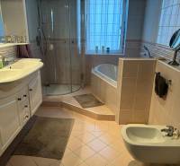 Koupelna v rodinném domě s vanou, sprchovým koutem, umyvadlem a bidetem.