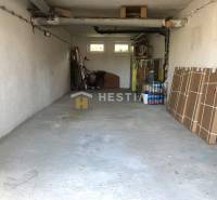 Garáž v 3-pokojovém bytě s odloženými předměty a kolem.