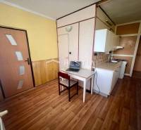 Kuchyně v 3-pokojovém bytě s jídelním koutem a dřevěnou podlahou.