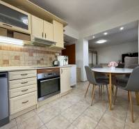 Kuchyně s kuchyňskou linkou a jídelním stolem v 2-pokojovém bytě.