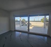 Interiér vily s velkým prosklením a výhledem na exteriér s bazénem.