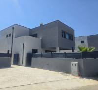 Vila v ulici Zukve ve Vrsi s moderní architekturou a palmou na dvoře.