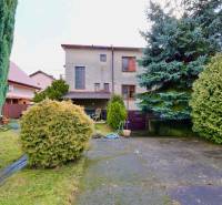 Zahrada rodinného domu na Kalinčiakově ulici v Michalovcích s upravenou zelení a terasou.