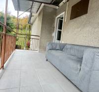 Terasa rodinného domu v Pruskom s pohovkou a výhledem na zeleň.