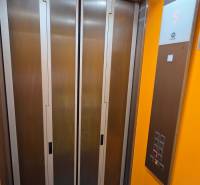 Výtah v budově, s tlačítky a displejem ukazujícím páté patro.