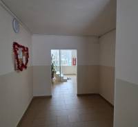 Chodba s bílými stěnami a světlou dlažbou v 3-pokojovém bytě.