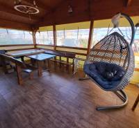 Oáza klidu se závěsným křeslem a dřevěným nábytkem na podlaze s dřevěným dekorem v Zahradách.