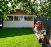 Zahrady v Dolních Krškanech, Nitra, s trávníkem, altánkem a dřevinami.