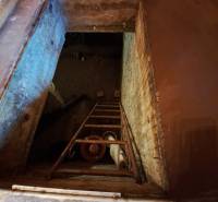 Pohled na sklepní otvor se schůdky v interiéru na Zahradách.