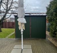 Zahrady v Dolních Krškanech v Nitře se složeným slunečníkem, zpevněnou plochou a trávníkem.