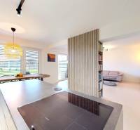 Otevřený interiér rodinného domu s kuchyní, jídelnou a pohodlným obývacím koutem.