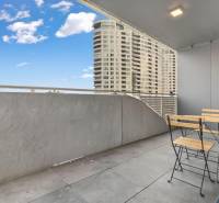 Balkon s moderním nábytkem, výhled na vysoké budovy v Bratislavě - Novém Městě.