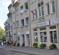 Budova s kanceláří cestovní agentury na Zámocké v Bratislavě, skupina osob na chodníku.