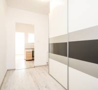 Interiér 2-pokojového bytu s podlahou s dřevěným dekorem a vestavěnou skříní.