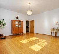 Rodinný dům s lustrem, skříní a podlahou s dřevěným dekorem v prostorném obývacím pokoji.