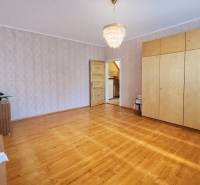 Interiér rodinného domu s podlahou s dřevěným dekorem, lustrem a vestavěnou skříní.