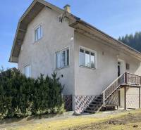 Rodinný dům v Terchové s velkými okny, schodištěm a udržovanou předzahrádkou.