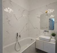 Koupelna s vanou, umyvadlem, zrcadlem a dekorativním svítidlem v 3-pokojovém bytě.