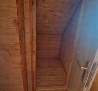 Dřevěný interiér v chatě s dřevěným dekorem a schodištěm.