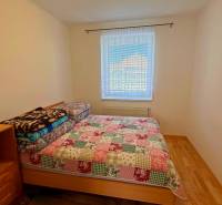 Ložnice v rodinném domě s postelí a podlahou s dřevěným dekorem.