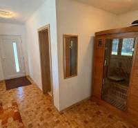 Chodba v rodinném domě s podlahou s dřevěným dekorem a vestavěnou saunou.