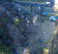 Letecký pohled na rekreační pozemky v Župkově obklopené hustými stromy.