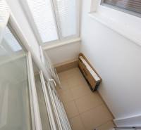 Balkon se sklápěcími dveřmi a dlažbou v 2-pokojovém bytě.