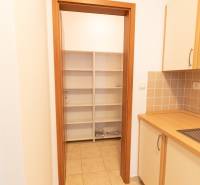 Kuchyně v 2-pokojovém bytě s poličkami a dlažbou, skříňky s dřevěným dekorem.