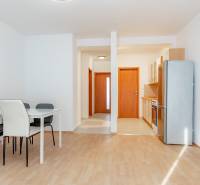 Kuchyně a jídelna s podlahou s dřevěným dekorem v 2-pokojovém bytě.