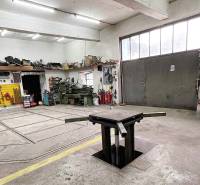 Dílna s nářadím, pracovním stolem a šachtou, bez přítomnosti lidí. Rodinný dům.