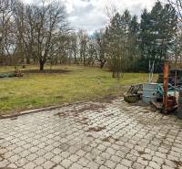 Pavlice, rodinný dům na Pavlicích s dlážděným dvorem, kůlnou a hromadou pneumatik.