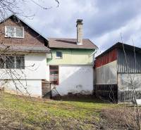 Rodinný dům ve městě Pavlice na ulici Pavlice s plechovou přístavbou a trávníkem.