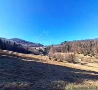 Rozsáhlé zemědělské a lesní pozemky v okolí Hronce obklopené lesy a kopci.