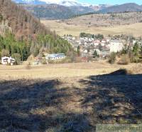 Výhled z pozemku na bydlení v Hronci obklopený horskou přírodou a lesy.