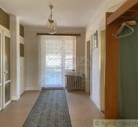 Interiér rodinného domu s podlahou s dřevěným dekorem, závěsem a kobercem.