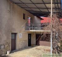 Rodinný dům v Bretce s balkonem, garáží a přístřeškem pro popínavé rostliny.