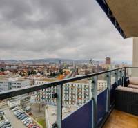 Výhled z balkonu 3pokojového bytu na Plynárenské ulici v Bratislavě se zahradním nábytkem.