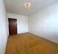 Pokoj s bílými stěnami a podlahou s dřevěným dekorem v 2-pokojovém bytě.