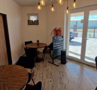 Interiér gastro prostorů s dřevěným dekorem a oknem poskytujícím výhled ven.