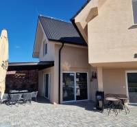 Exteriér gastro prostorů v Nové Dedince s terasou a moderním designem.