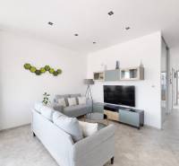 Obývací pokoj v 3-pokojovém bytě s moderním nábytkem a televizorem, dekorace na stěně.