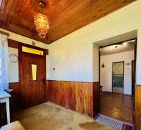 Dřevěný obklad na stěnách a stropě, barevný lustr, stolek v rodinném domě.