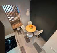 Kuchyňský kout v 2-pokojovém bytě s jídelním stolem a židlemi.